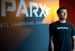CEO Russell Layton posing with the Sparx Logo